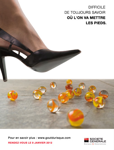 affiche avec le pied de femme avec chaussure à talon sur le point de se poser sur des billes éparses